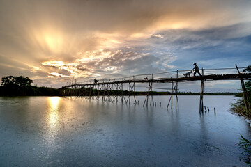Fototapeta na wymiar Farmers go to work on a bridge made of bamboo at Cam Dong village, Quang Nam province, Vietnam