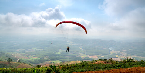Paragliding on Chu Tan Kra mountain peak in Sa Thay district, Kon Tum province, Vietnam   - obrazy, fototapety, plakaty