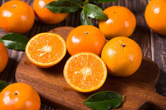 Fresh mandarin oranges or tangerines on wooden table. - Powered by Adobe