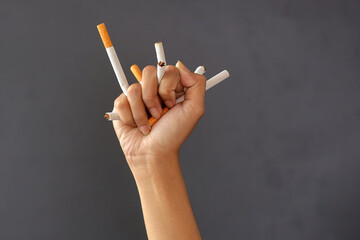 Hand crushing cigarettes. Concept of quitting smoking, World No Tobacco Day.