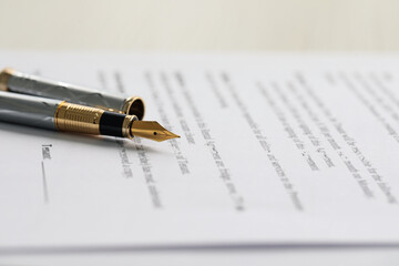 Fototapeta premium Fountain pen on paper document, closeup. Notary services