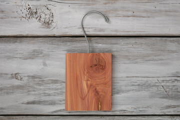 Isolate aromatic cedar block with a hanger on white wood background.