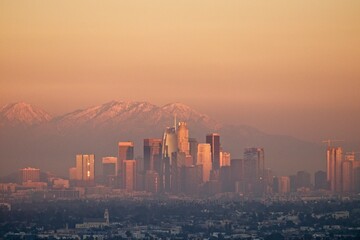 Snow tops the San Gabriel Mountains that tower above Los Angeles as evening falls on the city.