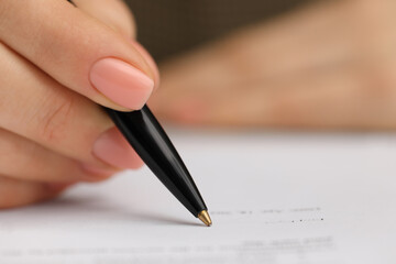 Woman signing document, closeup view. Space for text
