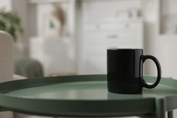 Blank ceramic mug on green table. Mockup for design