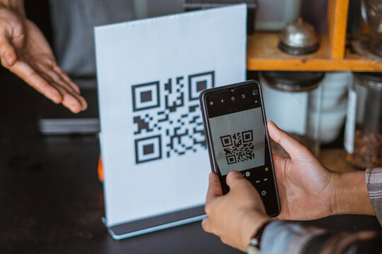 the hand of customer scanning the qr code using the phone