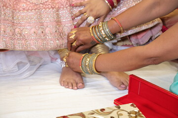 Woman wearing anklet in wedding ceremony getting ready in indian bride merriage.