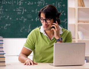 Handsome student in front of chalkboard with formulas