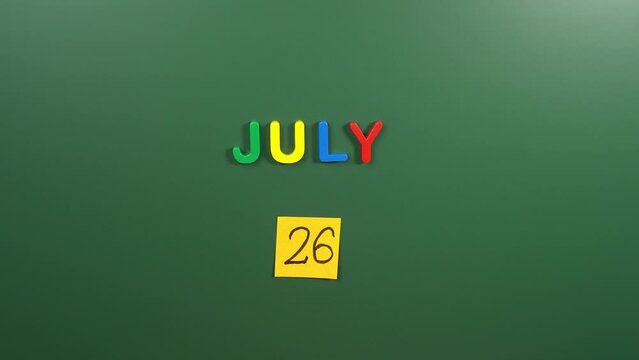 Hand sticking a sticker 26 July calendar day on school board. 26 date of July. Twenty sixth day of July. 26th date number. 26 day calendar. Twenty six date. Liberia independence, National Disability