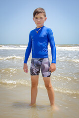 Fototapeta na wymiar Male teenager youth swimmer standing in the water at the beach
