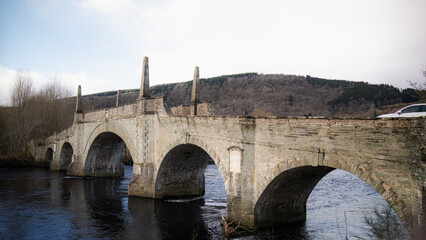 Fototapeta na wymiar old historical stone bridge. Water flows under the bridge