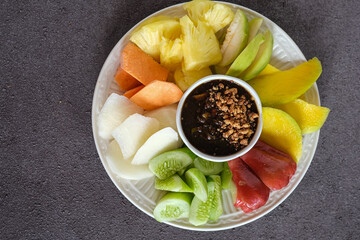 rujak buah ,mixed fruit with peanut sauce in white ceramic plate