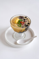es campur or mixed ice is Indonesian dessert made from tapai cassava, cendol, red bean, jelly and palm seed, served with coconut milk, palm sugar and ice
