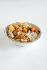 mie sop is a noodle and rice vermicelli in chicken soup with spices, topping shredded fried chicken, tofu and onion dan vegetables