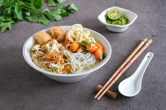mie sop is a noodle and rice vermicelli in chicken soup with spices, topping shredded fried chicken, tofu and onion dan vegetables