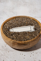 Chia seeds in wooden bowl. Copy space for your text. Healthy superfood rich in Omega 3 fatty acids. Dry healthy natural ingredient. Chia grains are falling. Vegetarian food 