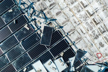 Aerial view of damaged by hurricane wind photovoltaic solar panels mounted on industrial building roof for producing green ecological electricity. Consequences of natural disaster © bilanol