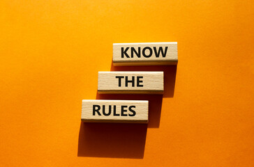 Know the rules symbol. Wooden blocks with words Know the rules. Beautiful orange background. Businessman hand. Business and Know the rules concept. Copy space.