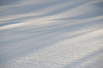 Lines of shadow and light on fresh white morning snow abstract background