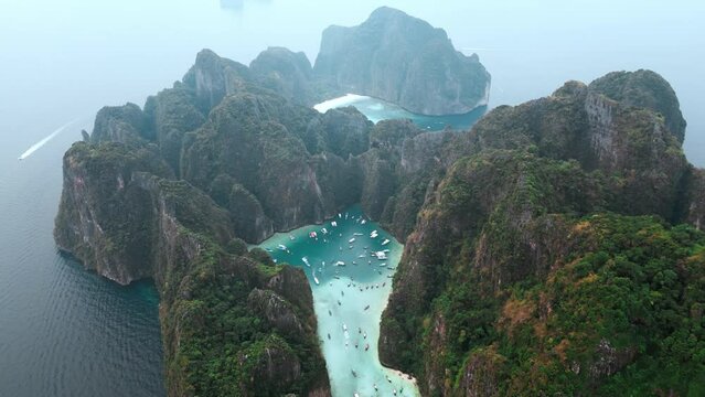 Beautiful natural tropical national reserve island in the sea. Thailand's most popular tourist attraction. Drone view iconic Maya Bay and Pi Leh Bay surrounded by limestone cliffs
