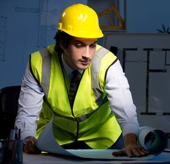 Young construction architect working on project at night