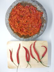 Indonesian Sambal Geprek chili sauce with tomato and garlic chili serve on pestle mortar stone called cobek