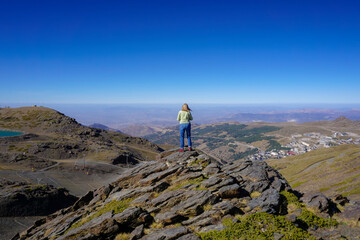 Young Caucasian woman dressed in jeans and sweatshirt enjoying the views of the Alpujarra valleys...