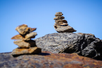 Flat gray stones piled up forming a pyramid and marking the path of a path in the mountains