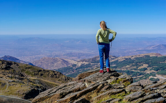 Young Caucasian woman dressed in jeans and sweatshirt enjoying the views of the Alpujarra valleys of Granada