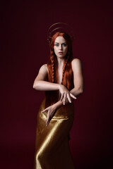 Close up fantasy portrait of beautiful woman model with red hair, goddess silk robes & gold crown. ...