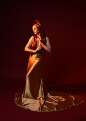 Full length fantasy portrait of beautiful woman model with red hair, goddess silk robes & gold...