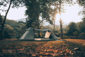 Gray tent on the grass in the forest The view behind is the mountain in the morning. Camping,...