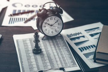Kings in chess suits and alarm clocks placed on financial documents to demonstrate excellence in...