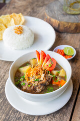 Delicious Oxtail Soup or Soup Buntut Served with Chili Sauce or Sambal and Steam Rice