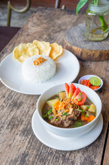 Delicious Oxtail Soup or Soup Buntut Served with Chili Sauce or Sambal and Steam Rice
