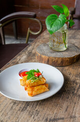 Delicious Asian Snack Spring Rolls or Lumpia Served with Chili Sauce on White Plate