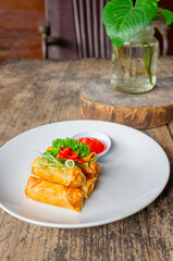 Delicious Asian Snack Spring Rolls or Lumpia Served with Chili Sauce on White Plate