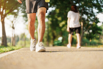 man jogging and walking on the road at morning with Energy Drink water, adult male in sport shoes...