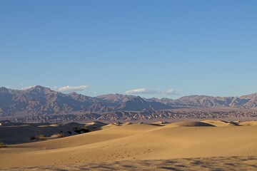 The Mesquite Flat sand dunes rise above Stovepipe Wells in Death Valley, with the Panamint Range...