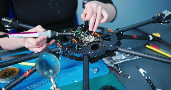 Engineer working on racing fpv drone combat kamikaze bomber in workshop.