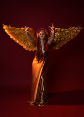 Full length portrait of beautiful woman model with long red hair, gold silk robes, crown & fantasy...