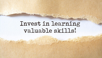 Invest in learning valuable skills. Words written under torn paper.