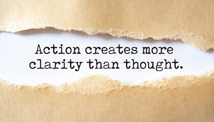 Action creates more clarity than thought. Words written under torn paper. Motivation concept text.