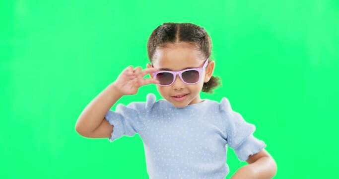 Cool, dance and a child with sunglasses on a green screen isolated on a studio background. Happy, funky and portrait of a dancing little girl with movements, being crazy and having fun with mockup