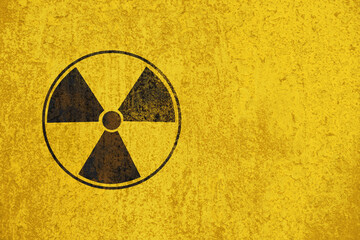 Nuclear energy radioactive round black symbol shape on yellow cement wall texture background with space. illustration of nuclear radiation or radioactive alert warning danger concept.