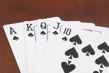 Close up of spades playing cards on wooden table.