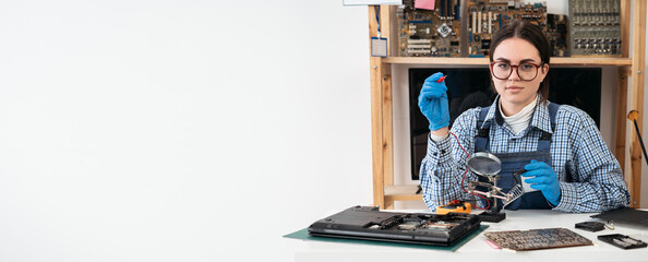 Laptop repair. Repairman working in technical support fixing computer laptop using multimeter or...