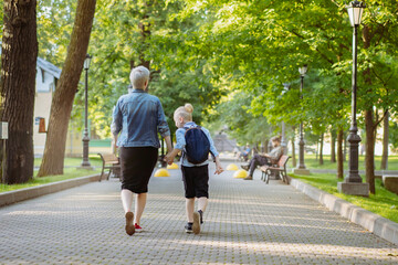 Obraz premium mother and son going to school holding hands