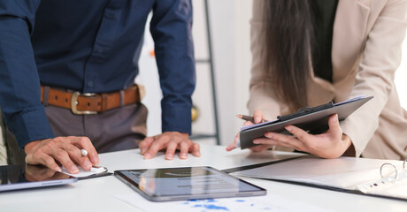 Cropped shot of accountant team working on laptop computer with business document, graph diagram and calculator on office table © wattana
