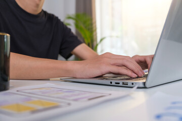 Web designer, UX UI designer using laptop, planning application process development prototype wireframe for web mobile phone .